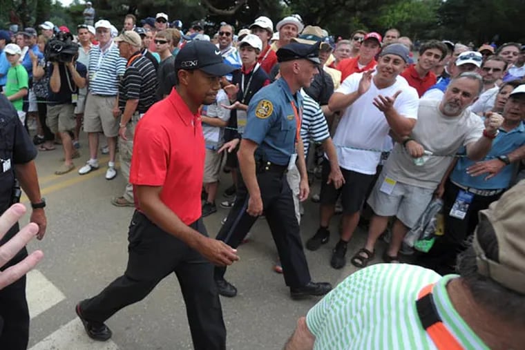 Tiger Woods is escorted through crowds of spectators as he makes his way to the 13th hole during the final day of the U.S. Open Sunday, June 16, 2013 at the Merion Golf Club in Ardmore, Pa. (AP Photo/The Express-Times, Matt Smith)