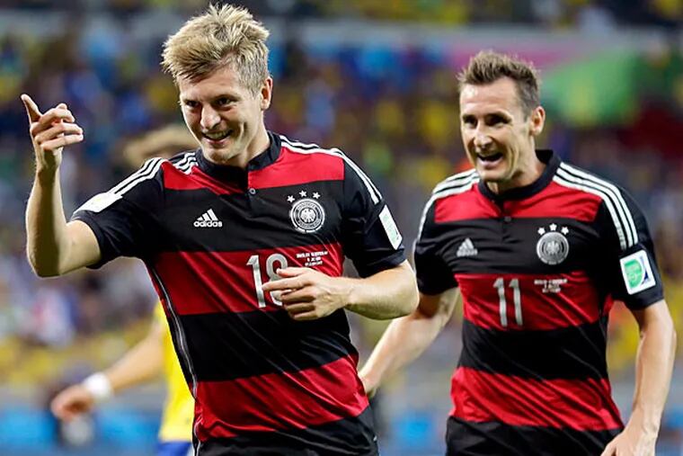 Germany's Toni Kroos, left, celebrates with Miroslav Klose (11) after scoring his side's fourth goal during the World Cup semifinal soccer match between Brazil and Germany at the Mineirao Stadium in Belo Horizonte, Brazil, Tuesday, July 8, 2014. (AP Photo/Natacha Pisarenko)
