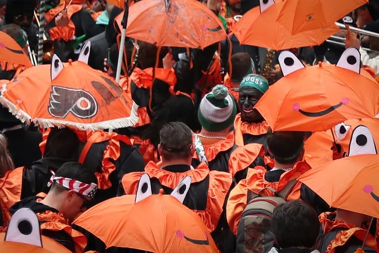A man in blackface is pictured in the crowd with the Froggy Carr wench brigade, at upper right, during the Mummers Parade in Philadelphia, PA on January1, 2020.