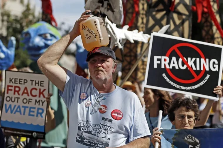 FILE – In this Sept. 20, 2012, file photo, Ray Kemble, of Dimock, Pa., holds a jug of his well water on his head while marching with demonstrators against hydraulic fracturing outside a Marcellus Shale industry conference in Philadelphia. Federal government scientists are collecting water and air samples in the first week of August 2017 from about 25 homes in Dimock, Pa., a tiny, rural crossroads about 150 miles north of Philadelphia that became a flashpoint in the national debate over fracking.