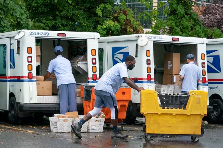 Letter carriers load mail trucks for deliveries at a U.S. Postal Service facility in McLean, Va., last month. President Donald Trump has repeatedly raised unsubstantiated fears of fraud involving mail-in voting, which is expected to be more widely used in the November election out of concern for safety given the COVID-19 pandemic.