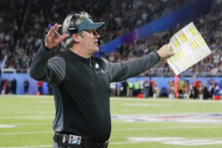 Eagles head coach Doug Pederson raises his arms after his defense stopped the New England Patriots in Super Bowl LII on Sunday, February 4, 2018 in Minneapolis.