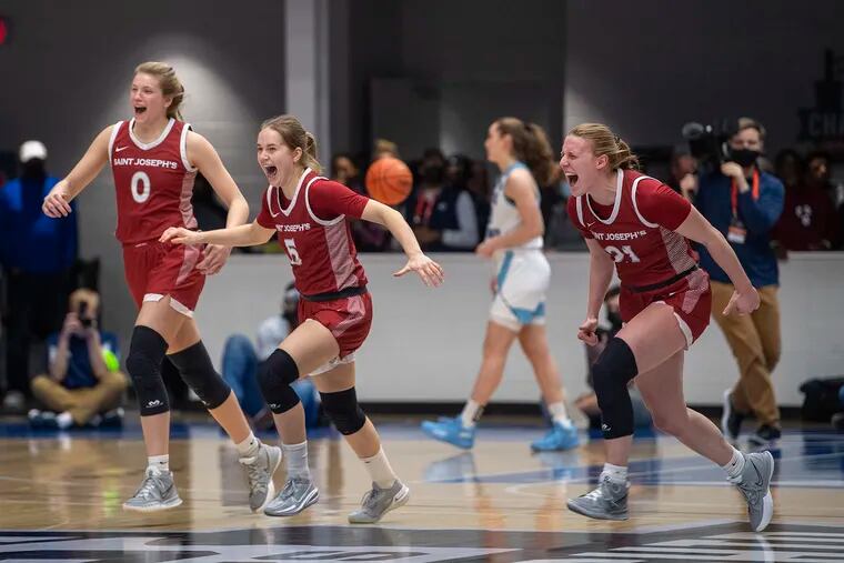 From left, St. Joe's Talya Brugler, Julia Nystrom, and Mackenzie Smith celebrate at the end of the game after defeating Rhode Island in the Atlantic 10 women's basketball tournament quarterfinals. All three are back and expected to lead the Hawks this season.