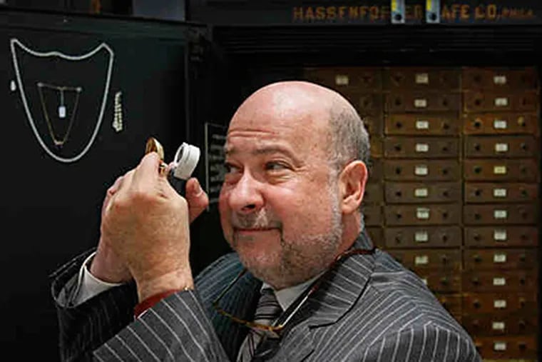 Tod Gordon examines jewelry at Carver W. Reed & Co. Inc., a high-end pawnshop at 10th and Sansom Streets that deals only in gold and diamonds. (Michael S. Wirtz / Staff)