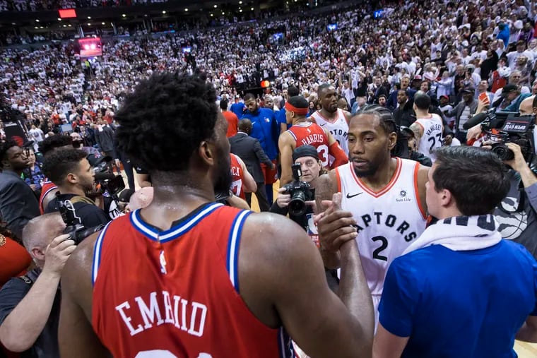 Sixers center Joel Embiid, left, and former Sixer T.J. McConnell congratulated Kawhi Leonard after Leonard hit the game-winning shot in Game 7 of the NBA Eastern Conference semifinals at the Scotiabank Arena in Toronto on May 12.