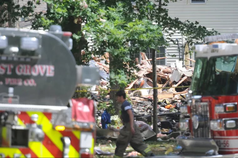 Fire personal along the 300 block of Oakwood Avenue in Newfield, New Jersey, where officials say a house explosion killed two early Saturday, July 7, 2018.