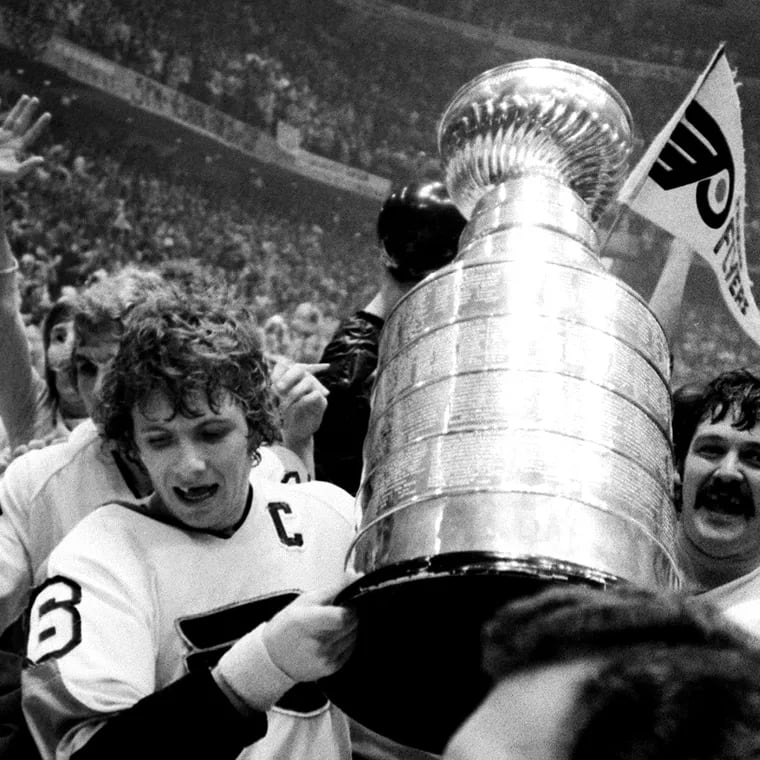 Flyers captain Bobby Clarke (left) and goalie Bernie Parent hoist the Stanley Cup after beating the Boston Bruins in 1974.