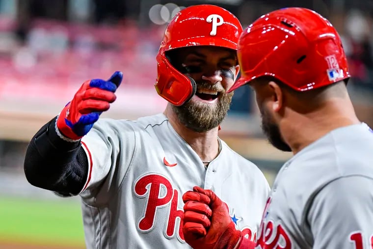 Philadelphia Phillies designated hitter Bryce Harper (left) congratulates teammate Kyle Schwarber (right) after Schwarber hit a home run against the Houston Astros on Oct. 3 in Houston. The Phillies and Astros face off in the 2022 World Series, which begins Friday. (Photo by Logan Riely/Getty Images)