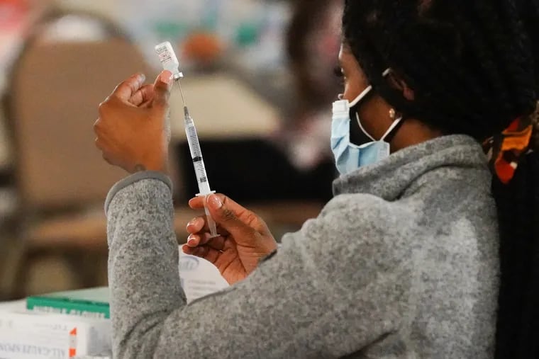 A health worker prepares a vaccine dose during a vaccination clinic at the Grand Yesha Ballroom in South Philadelphia on Wednesday.