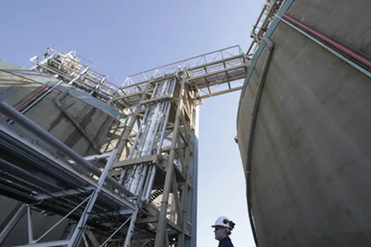 At Philadelphia Gas Works Richmond plant, program manager James Kluzinski stands between two huge storage tanks of liquid natural gas. (Michael S. Wirtz / Staff Photographer)