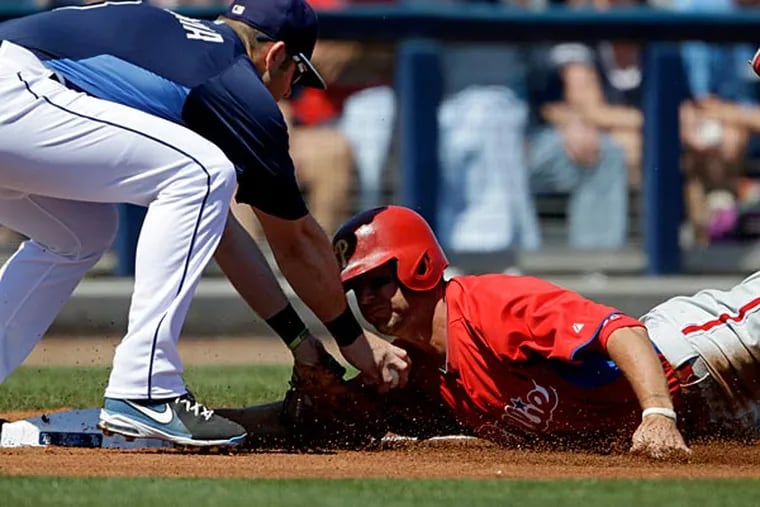 Tampa Bay Rays' Evan Longoria, left, waits with the ball to tag out Philadelphia Phillies' Kevin Frandsen, right, as he slides into third base off a hit by Michael Young in the first inning of a spring training exhibition baseball game, Friday, March 8, 2013, in Port Charlotte, Fla. (AP Photo/David Goldman)