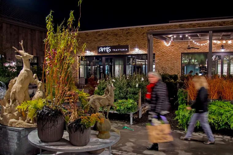 Shoppers pass between the garden ware at Terrain (left) and Amis Trattoria (rear) in Devon Yard, the new Urban Outfitters Multi-Brand Retail Complex In Devon.