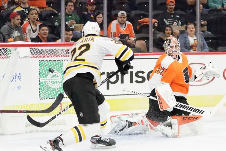 Flyers goalie Brian Elliott watches Boston Bruins left wing Peter Cehlarik score a goal.