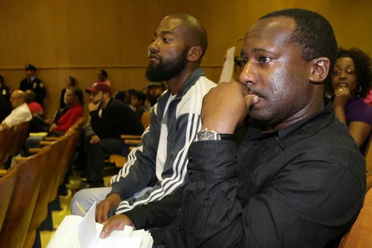 John Phillips (right) and Will Little, ex-offenders who turned their lives around, listen as Mayor Nutter talks budget cuts at a town meeting Wednesday. A plan to help ex-offenders has hit problems.