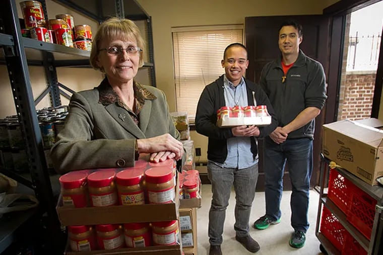 Sister Linda Lukiewski runs a food pantry for the needy out of the rectory of St. Joan of Arc in Philadelphia. She is assisted by Andrew Corriente (left) and Andre Repucci, both Franciscan brothers. ( ALEJANDRO A. ALVAREZ / STAFF PHOTOGRAPHER )