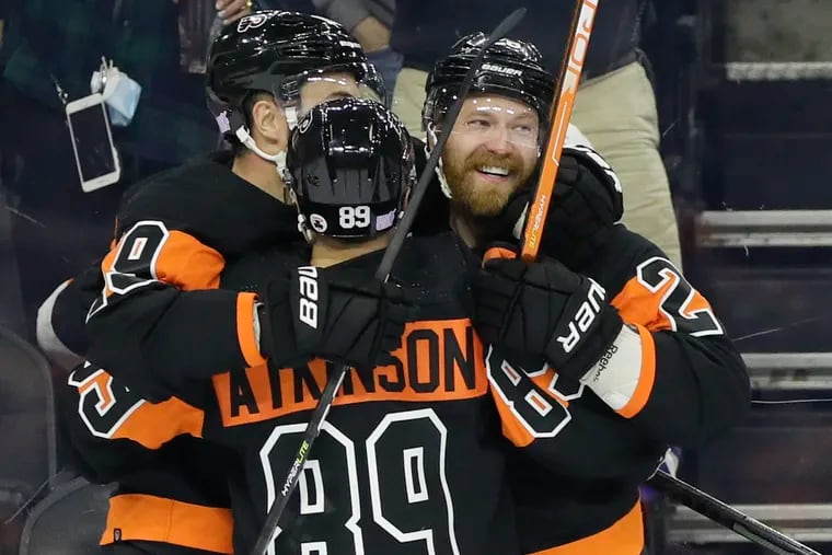 Flyers left winger Claude Giroux (right) celebrates his first-period goal with right winger Cam Atkinson and center Derick Brassard against the Tampa Bay Lightning on Thursday. Giroux also scored late in regulation to tie the score at 3-3.