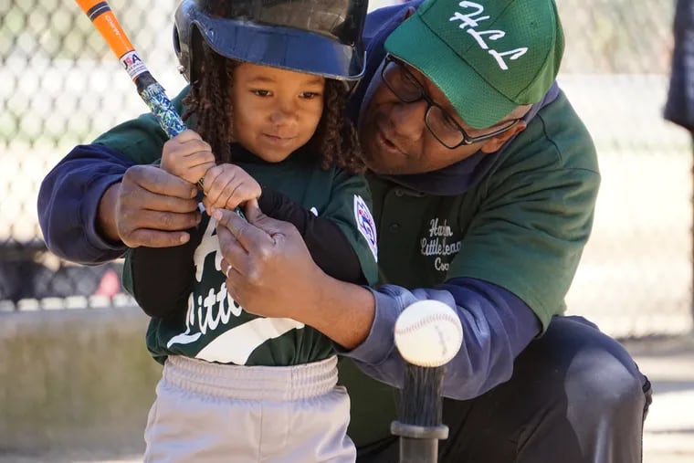 Polly Mercier received instruction on how to hit a tee-ball from her father, Rob Mercier.