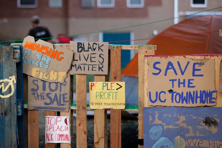 Signs erected outside of the University City Townhomes in Philadelphia, where an encampment and protest began because of the planned sale and redevelopment of the property, on July 21.