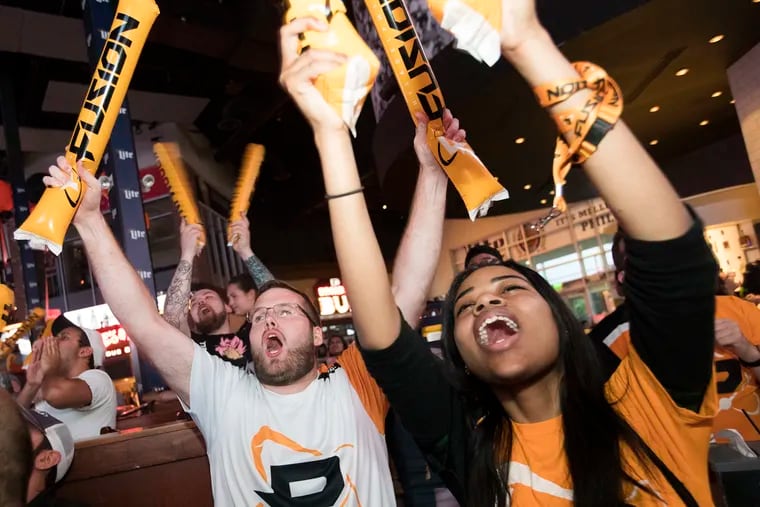 Philadelphia Fusion fans, including Max Henning, left, and Sierrah Rhodes, celebrate during the esports team's 3-1 victory over the Boston Uprising in the Overwatch League World Championship playoffs on July 11, 2018.