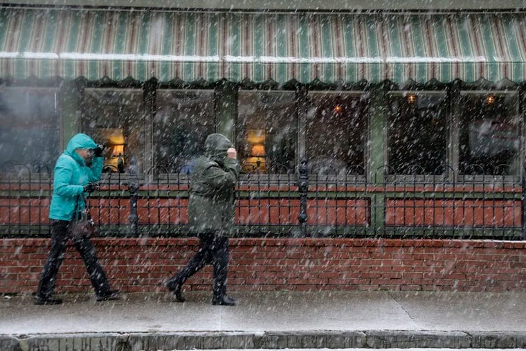 Pedestrians make their way through a wintry mix of weather in Mount Holly in November 2018.