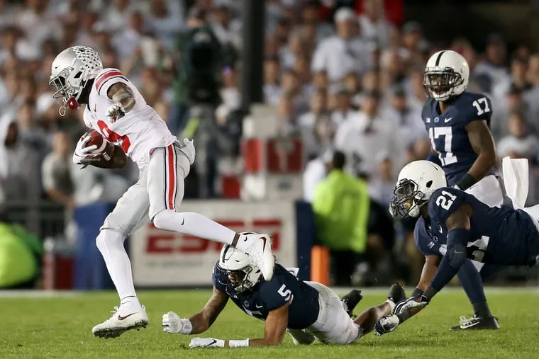 Ohio State wide receiver Binjimen Victor (9) evades a tackle by Penn State cornerback Tariq Castro-Fields (5) on a touchdown run in the fourth quarter of Penn State's loss on Saturday.
