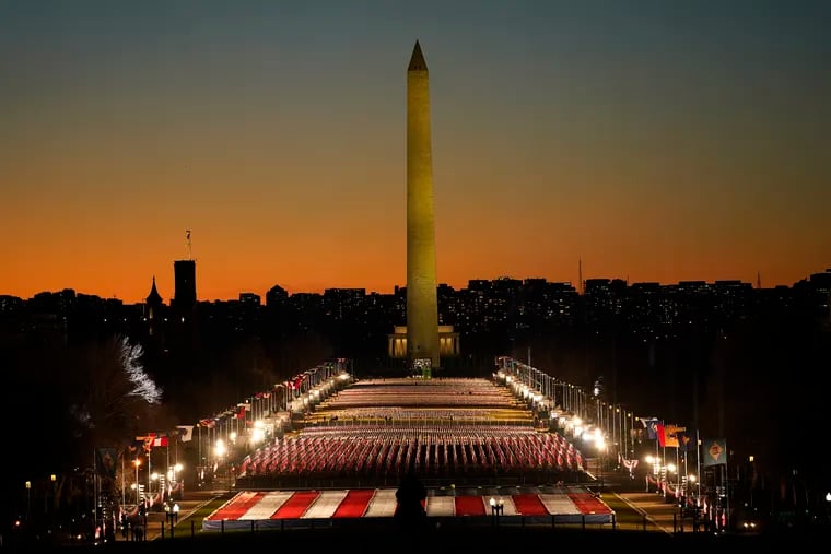 A field of flags is spread across the National Mall, with the Washington Monument in the background on Tuesday, Jan. 19, 2021, ahead of the 59th Presidential Inauguration in Washington. The flags honored the hundreds of thousands of people who died due to COVID-19.