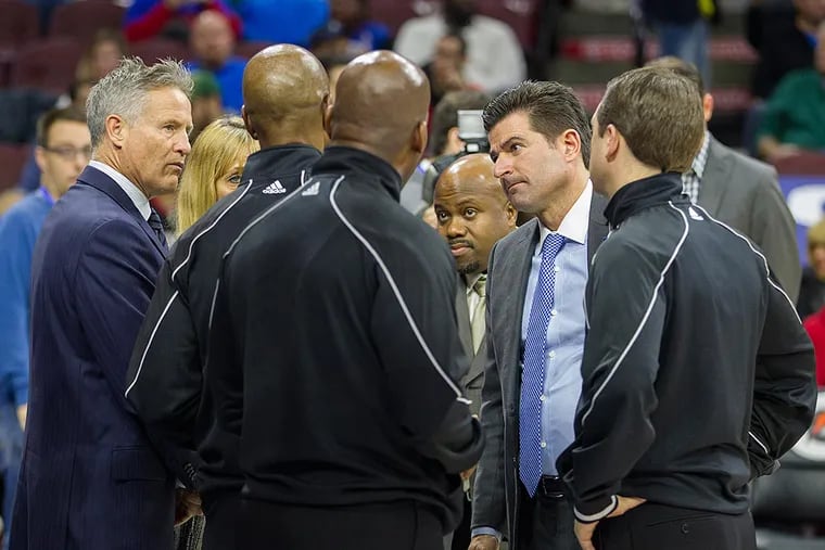 Scott O'Neil (second from right) huddles with the officials and then-coach Brett Brown (left) before a 76ers game.