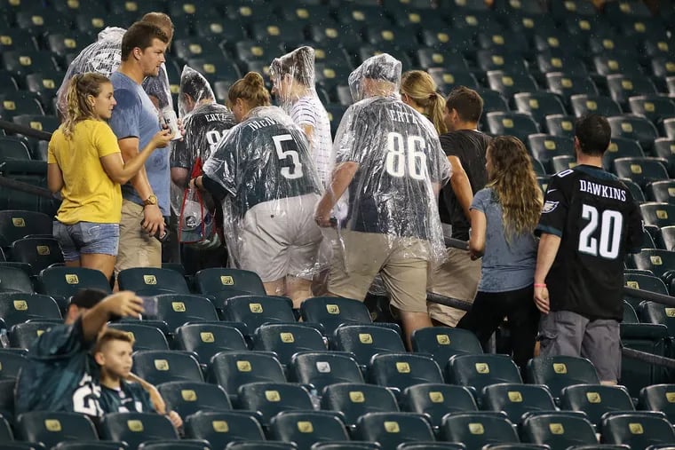 Eagles fans leave the stands after lightning forced a delay during a preseason game against the Baltimore Ravens  on Thursday.