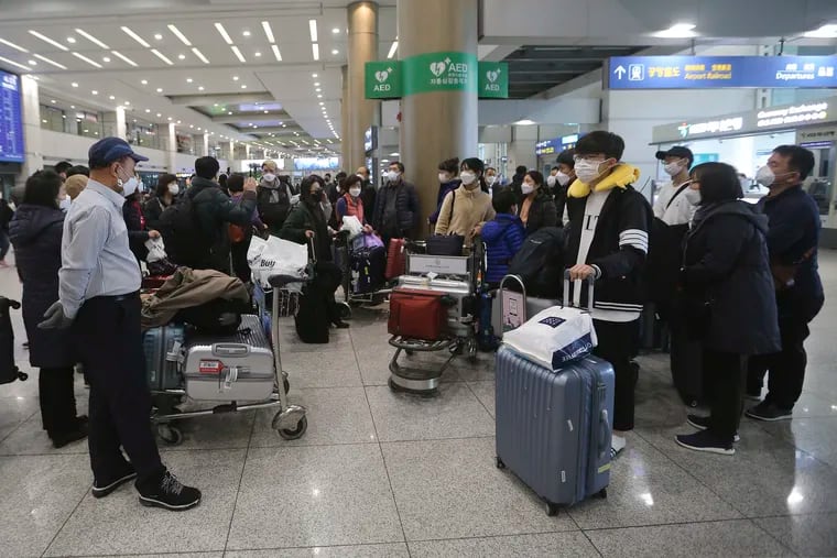 South Koreans tourists gather after returning from Israel at Incheon International Airport in Incheon, South Korea, Tuesday, Feb. 25, 2020.