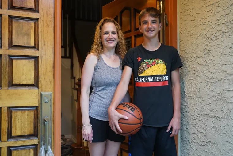Hannah Bookbinder and her son Zach Bookbinder, 14, pose for a portrait outside their home in Penn Valley. Zach has planned an upcoming basketball tournament. After he read a story about a young teen who was shot an paralyzed and wanted to help.