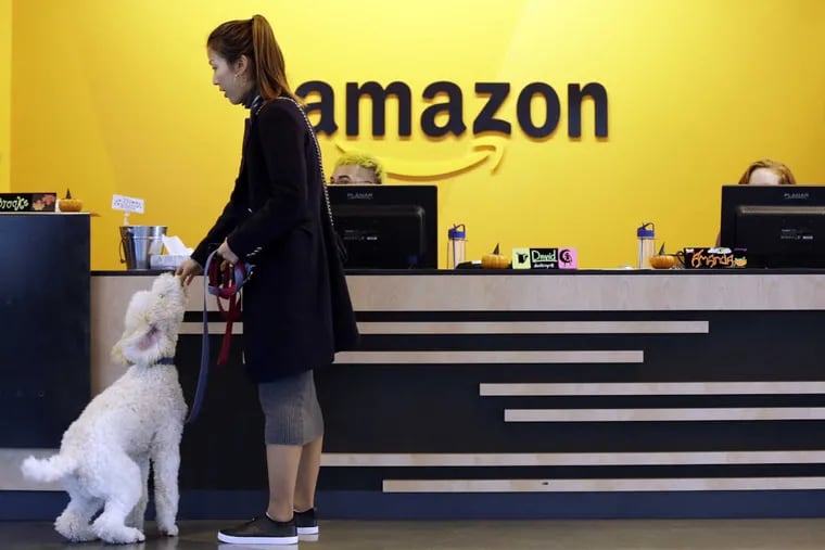 In this Wednesday, Oct. 11, 2017, file photo, an Amazon employee gives her dog a biscuit as the pair head into a company building, where dogs are welcome, in Seattle. Amazon announced Thursday, Jan. 18, 2018, that it has narrowed its hunt for a second headquarters to 20 locations, concentrated among cities in the U.S. East and Midwest. Toronto made the list as well, keeping the companyâ€™s international options open.