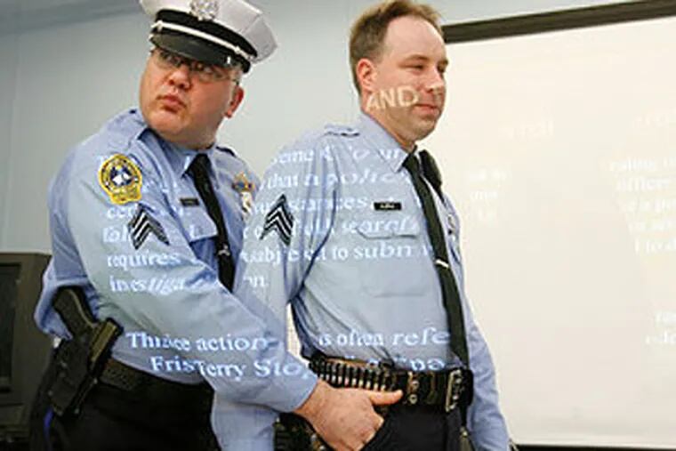 Philadelphia Police Sgt. D.F. Pace puts his fingers into Sgt. Martin Klepac's pocket, an illegal move during a frisk in this 2008 file photo. (Charles Fox / Staff Photographer)