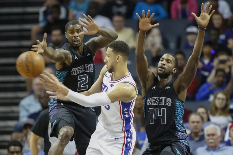 76ers guard Ben Simmons passes around a double team by Charlotte Hornets forwards Marvin Williams (2) and Michael Kidd-Gilchrist.
