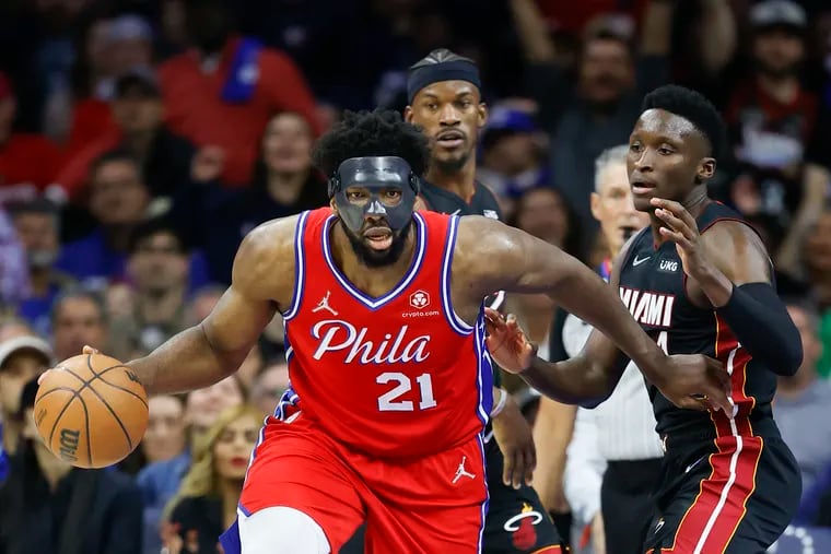 Sixers center Joel Embiid dribbles the basketball against Miami Heat guard Victor Oladipo in Game 4.