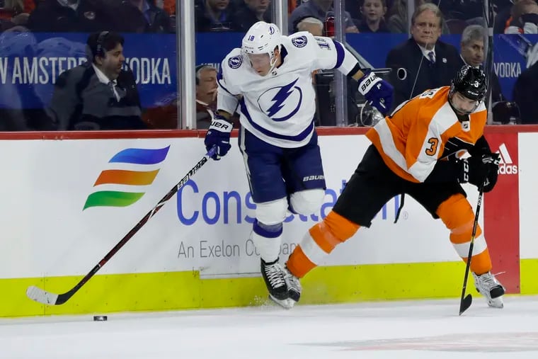 Tampa Bay Lightning's Ondrej Palat, left, reaches for the puck after a collision with the Flyers' Radko Gudas during the second period Tuesday. Gudas was involved in a third-period incident and was suspended for two games by the NHL on Wednesday.