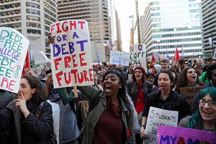 People march to Philadelphia City Hall over the heavy burden of student loans, as expressed on these signs. (Clem Murray/Philadelphia Inquirer/TNS)