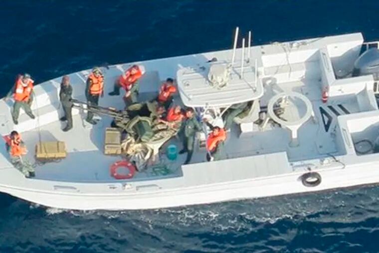 This image released by the U.S. Department of Defense on Monday, June 17, 2019, and taken from a U.S. Navy helicopter, shows what the Navy says is the Islamic Revolutionary Guard Corps Navy after removing an unexploded limpet mine from the M/T Kokuka Courageous.  (U.S. Department of Defense via AP)
