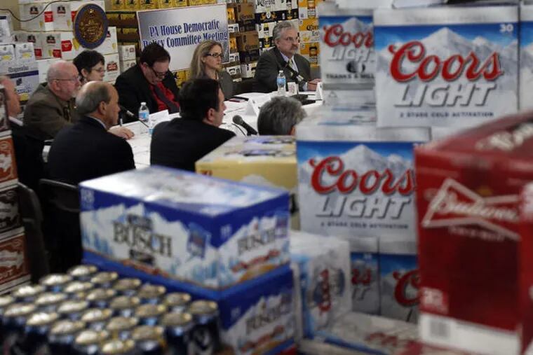 Stacks of cases of beer surround members of the House Democratic Policy Committee during a hearing on the Privatization of State Liquor Stores at Big Top Beverage Market in Abington, Pa. on March 27, 2013.  ( DAVID MAIALETTI / Staff Photographer )