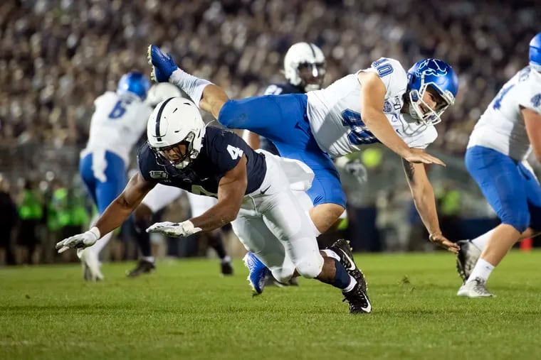 Penn State running back Journey Brown (4) tips a punt by Buffalo punter Evan Finegan (40) in the third quarter. Finegan was injured on the play and carted off the field.