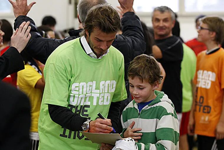 David Beckham, signing autographs in a school in Zurich, is beating the drum for England's 2018 World Cup bid. (AP Photo/Matthew Childs, Pool)