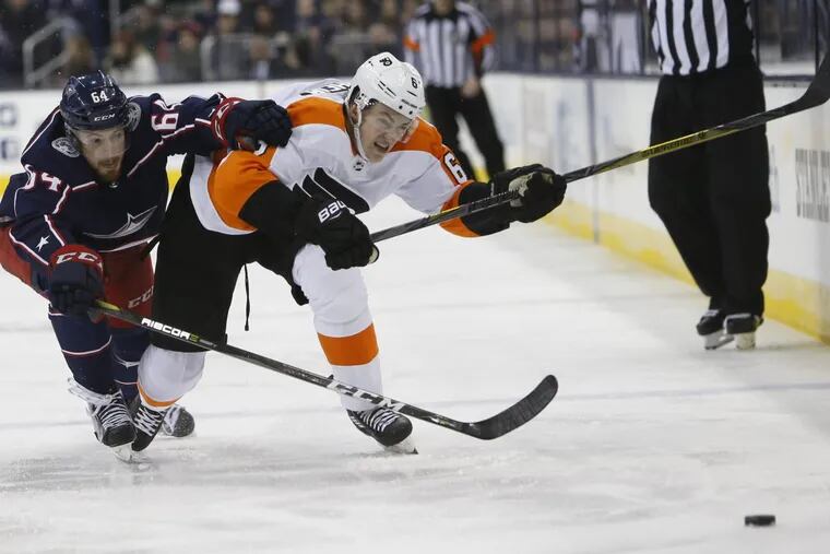 Flyers rookie Travis Sanheim (right) battles Columbus’ Tyler Motte for a loose puck in a recent game.