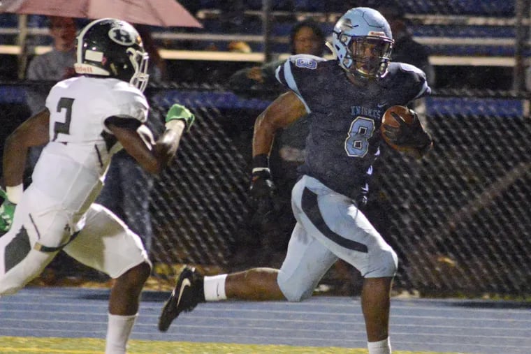 North Penn'ss Shamar Edwards runs with the ball as Ridley's Elijah Yakpasuo (2) gives chase in a District 1 Class 6A first-round playoff contest.