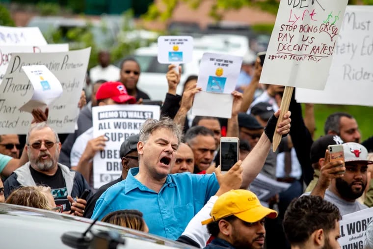 Gregory Lioi, an Uber driver and protestor, shouts in front of the Uber Green Light Hub near the Philadelphia Airport on Wednesday. Uber drivers and their supporters rallied to fight for fair wages and delivered a set of five demands to the manager at Philadelphia's Uber Green Light Hub.