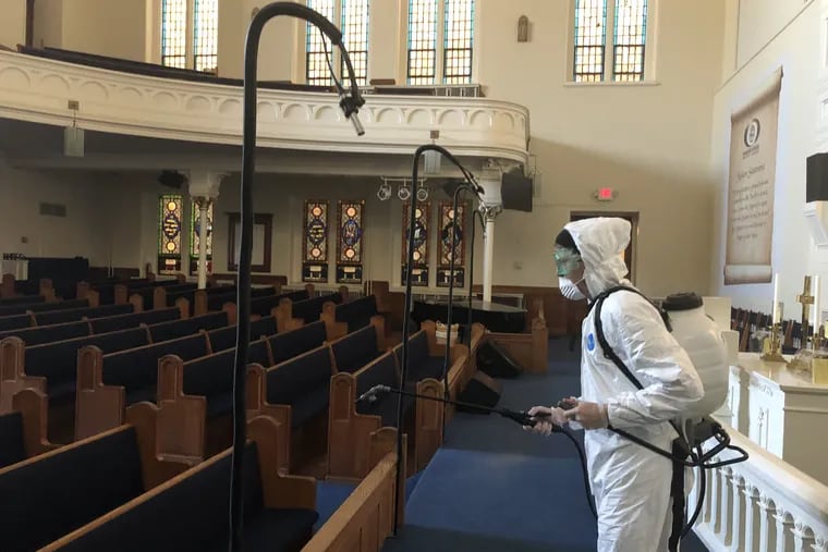 A worker cleans the sanctuary at Greater Exodus Baptist Church on North Broad Street. Although many churches have closed because of the coronavirus epidemic, some worshippers are still attending services at Greater Exodus.