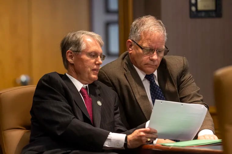 James H. Grossman Jr. (left), who heads PSERS's investment staff, goes over a document with fund board chairman Christopher Santa Maria during a recent board meeting.  Six members of the 15-member panel sought to fire Grossman recently but could not win majority support.   Santa Maria did not support the dismissal.