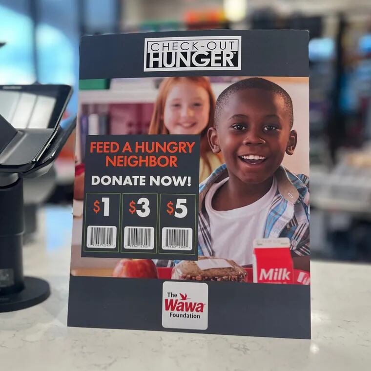 A Check-out Hunger sign, asking customers if they'd like to make $1, $3, or $5 donation, is displayed at a Wawa store.