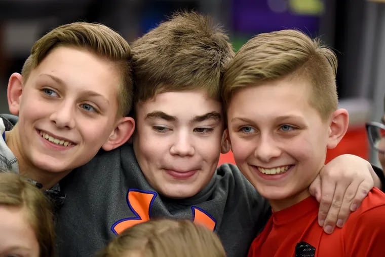 Connor Dobbyn hugs longtime friends and with grade classmates twin brothers James (left) and Jack Felmlee (right) in their room during recess (it was raining outside) at West Vincent Elementary School in Chester Springs Feb. 13, 2020. He is diagnosed with terminal one-in-a-million-rare Sanfilippo Syndrome - "childhood Alzheimer's."