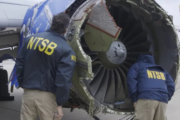 In this Tuesday, April 17, 2018 frame from video, a National Transportation Safety Board investigator examines damage to the engine of the Southwest Airlines plane that made an emergency landing at Philadelphia International Airport in Philadelphia.