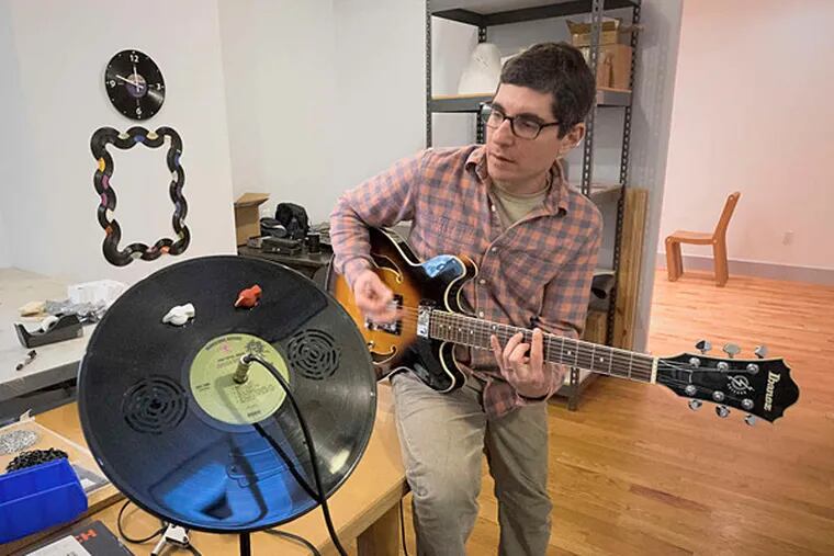 Jeff Davis plays his electric guitar, plugged into an amplifier he designed and made using an LP.
