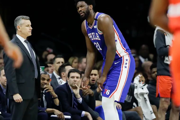 Sixers center Joel Embiid reacts after injuring his finger during the first-quarter next to Oklahoma City Thunder Head Coach Billy Donovan on Monday, January 6, 2020 in Philadelphia.